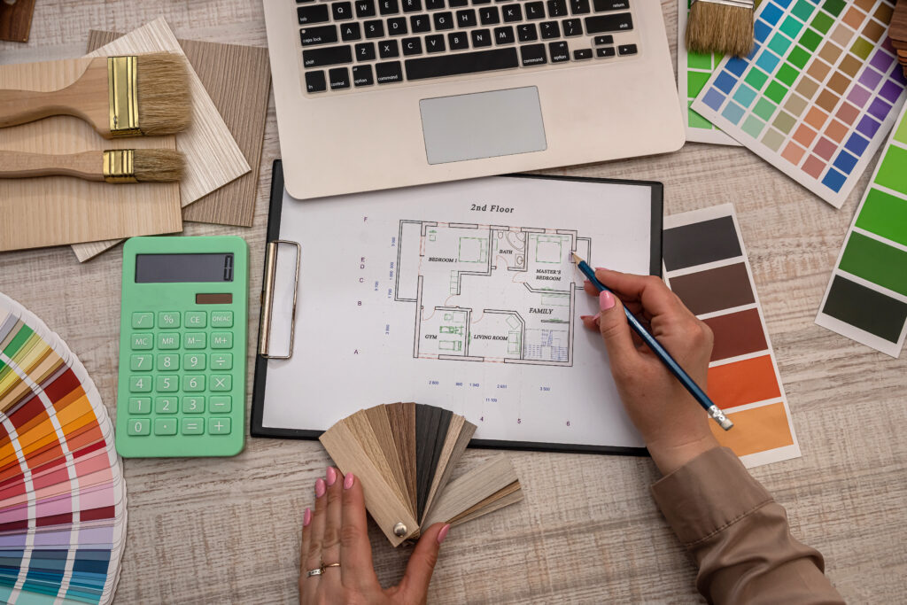 DSB Home Interiors - female hand selects a color from the palette on architectural plan, renovation concept