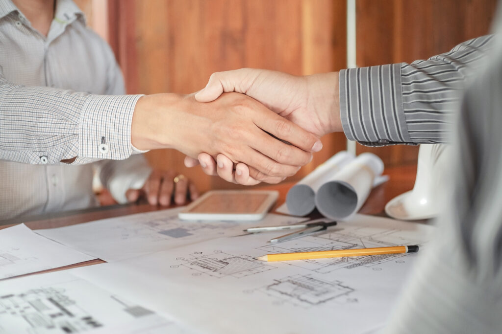 DSB Home Interiors - Engineer handshake together with blueprint in workplace.